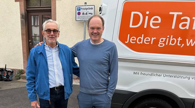 Dr. H. H. Weyer (Freiburger Tafel e.V.) und Dirk Westermann (Uniklinik Freiburg) stehen vor einem Fahrzeug der Freiburger Tafel.